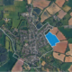 Aerial view of a town with fields; one area is highlighted in blue within a white boundary.
