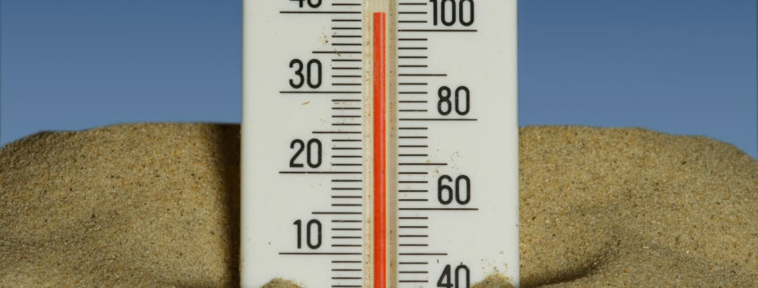 A thermometer in sand shows a temperature of about 37°C, set against a blue background.